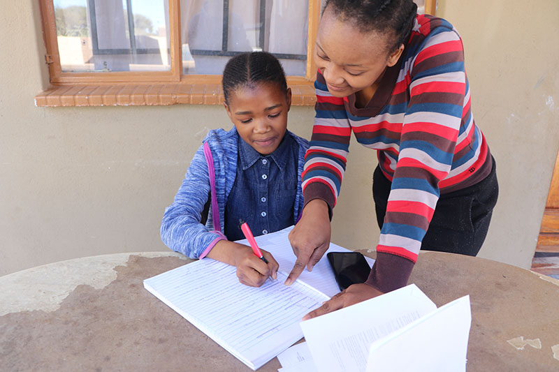 Caregiver and learner working in a book with an app based tool