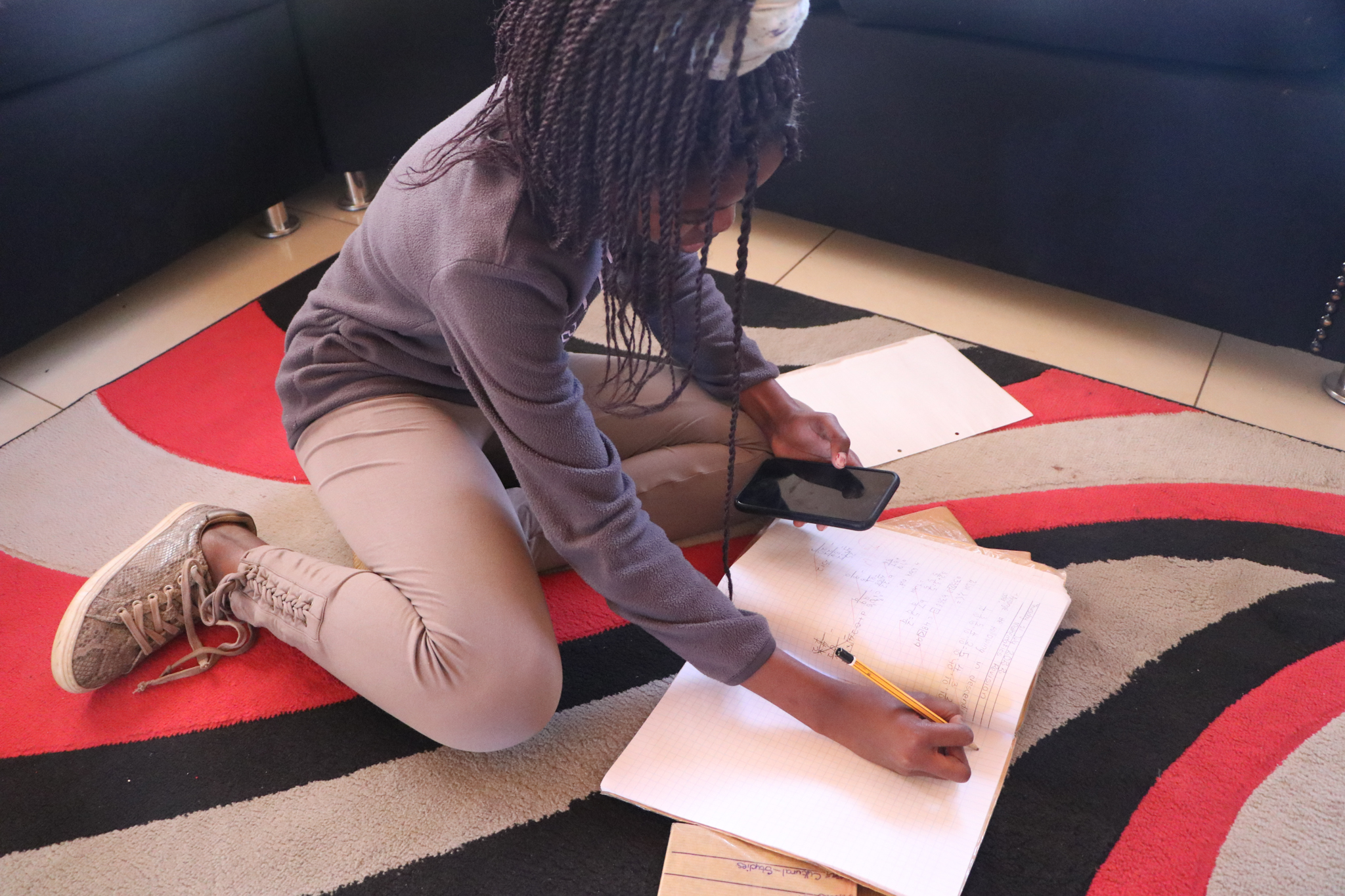 Learner working with app and schoolbook