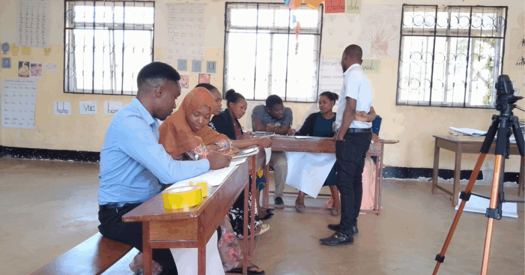 The picture shows a male peer facilitator in a Community of Learning session (CoL) in one primary school we visited, despite a higher ratio of female teachers being present. 
